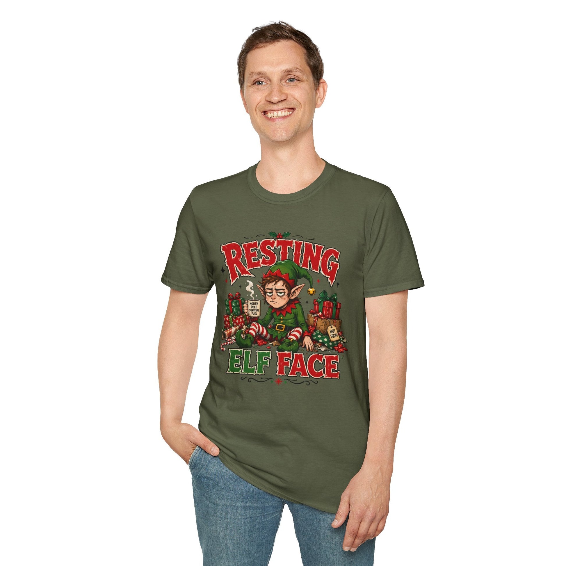 Model wearing the Resting Elf Face Christmas T-Shirt in military green with funny tired elf artwork.