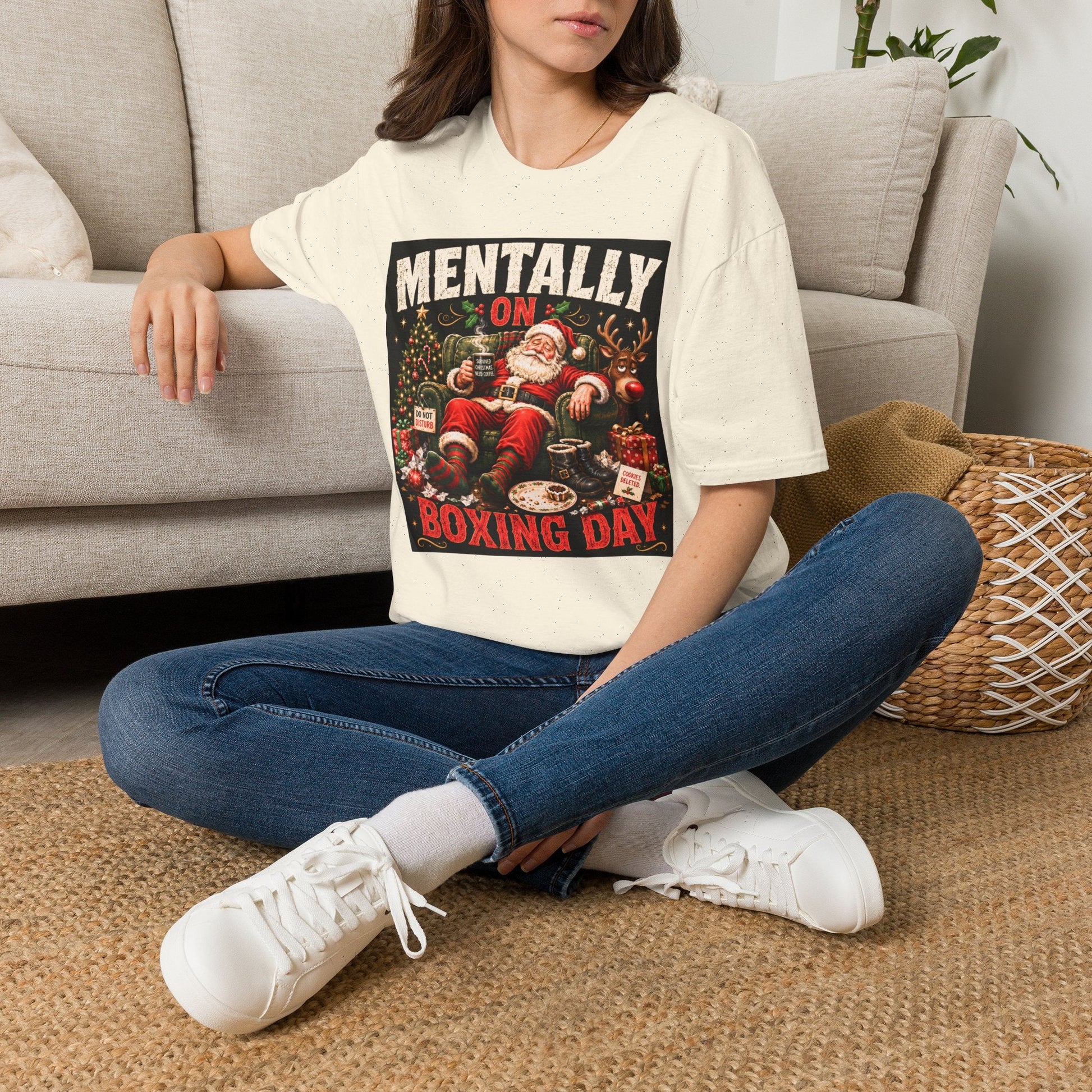 Model wearing the Mentally on Boxing Day Santa Christmas T-Shirt in natural with funny exhausted Santa artwork.