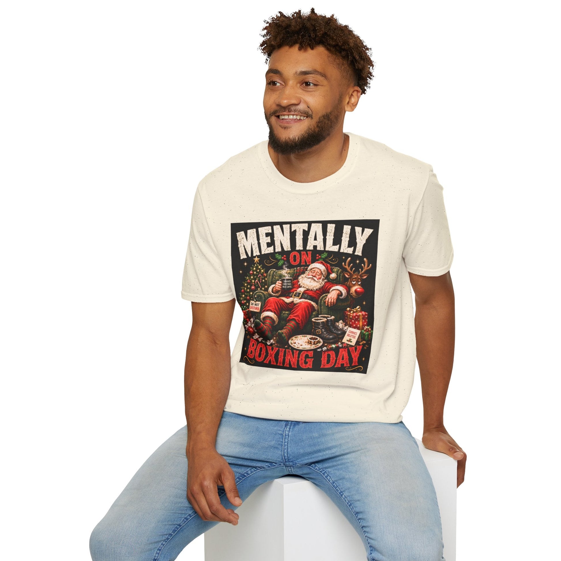 Model wearing the Mentally on Boxing Day Santa Christmas T-Shirt in natural with funny exhausted Santa artwork.