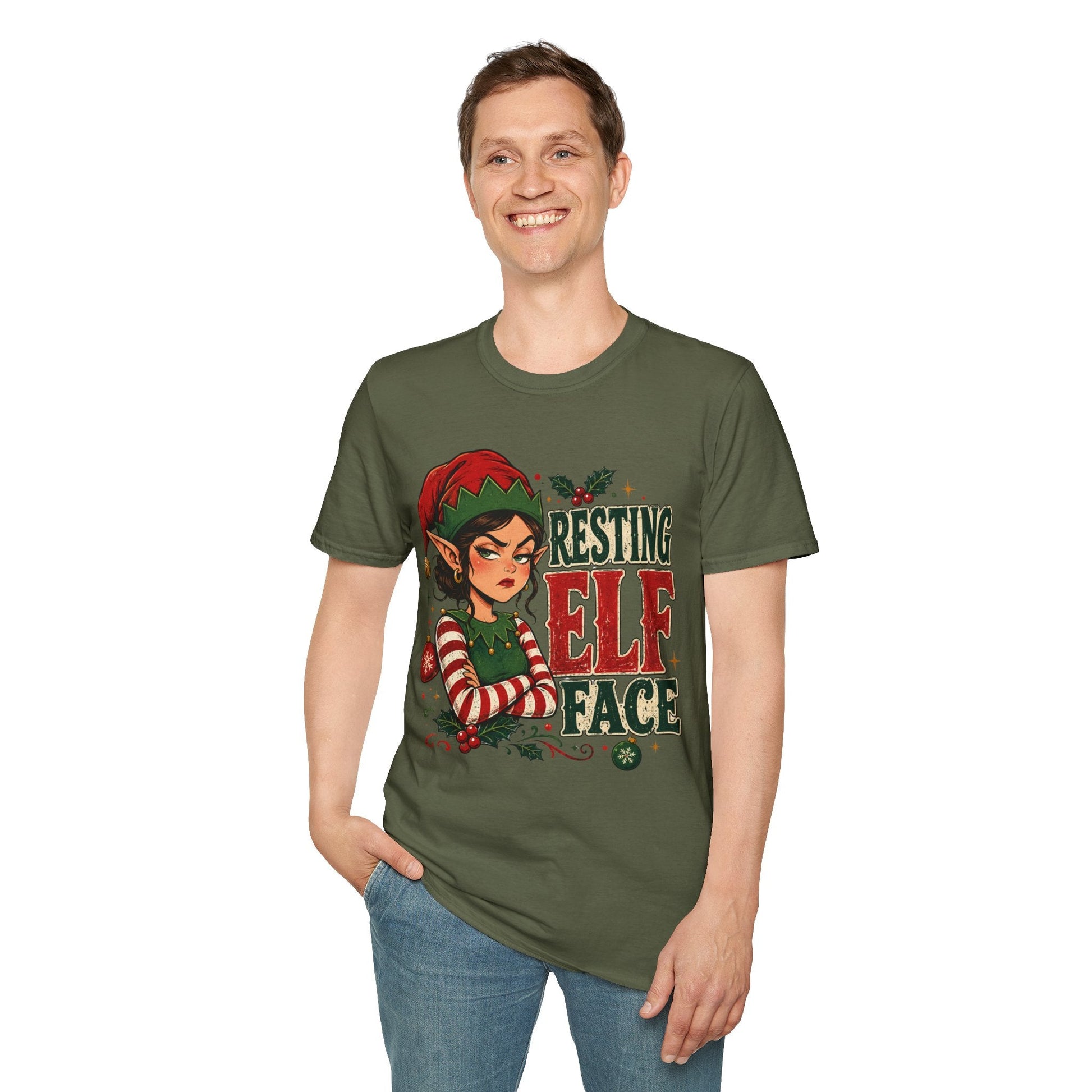 Model wearing the Resting Elf Face Sassy Elf Christmas T-Shirt in military green with funny Christmas elf artwork.