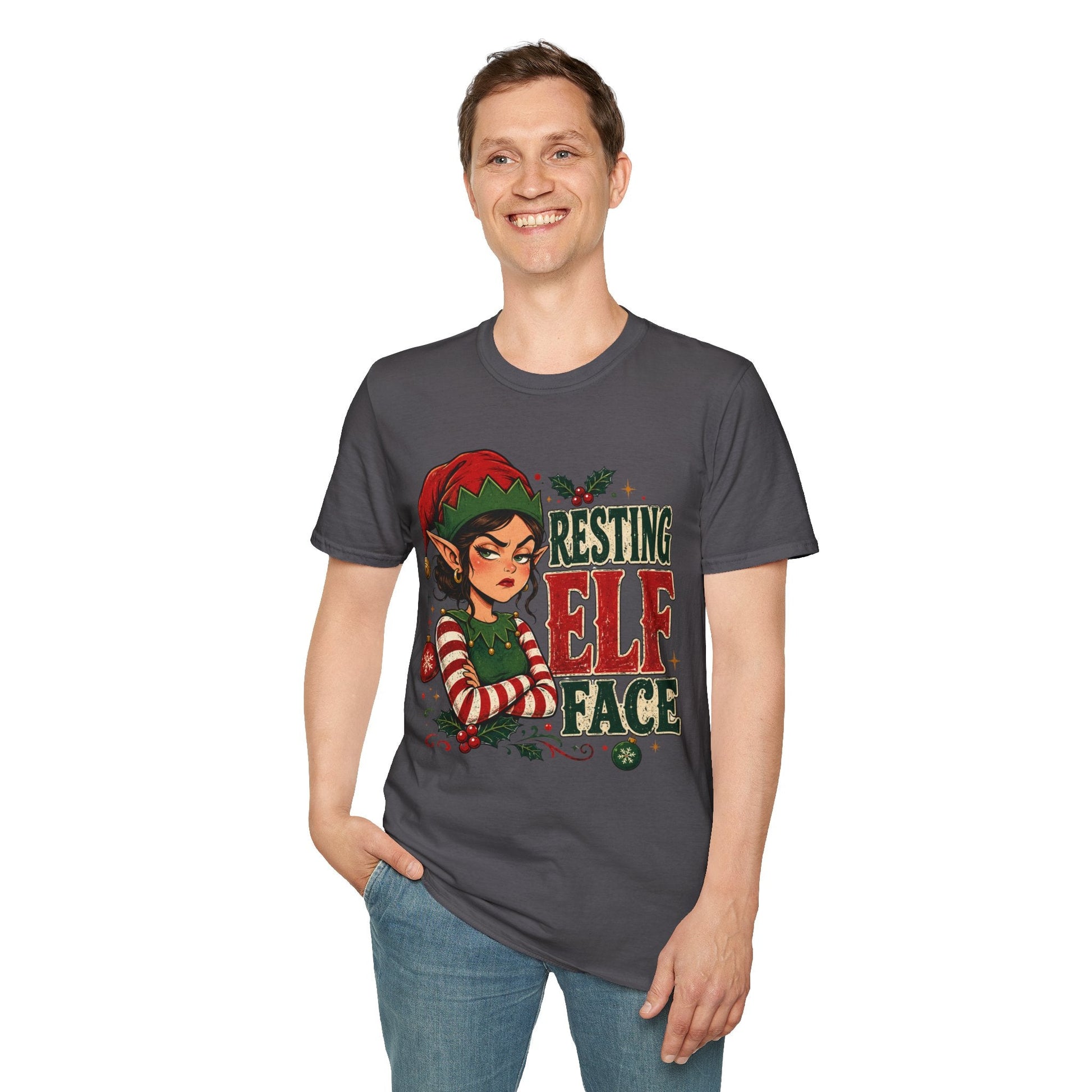 Model wearing the Resting Elf Face Sassy Elf Christmas T-Shirt in charcoal with funny Christmas elf artwork.