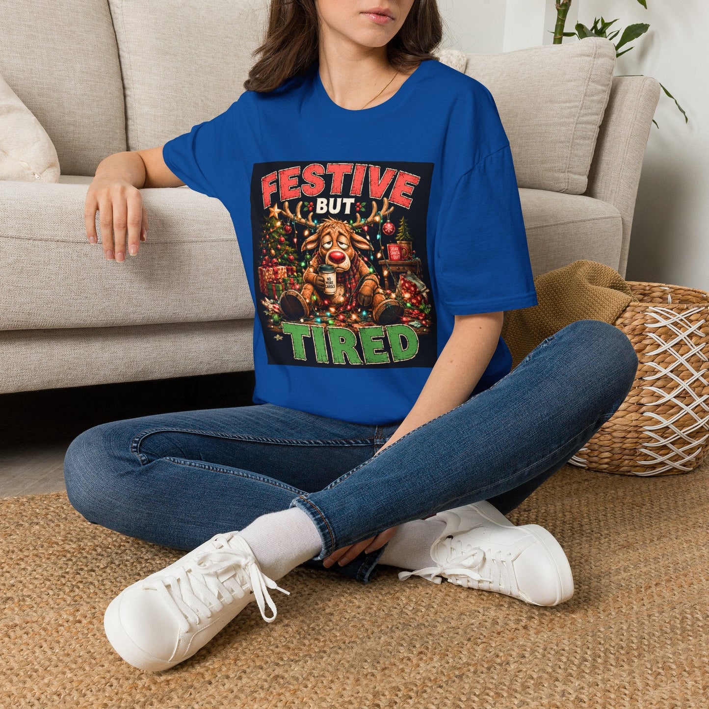 Model wearing the Festive But Tired Reindeer Christmas T-Shirt in royal with funny tired reindeer artwork.