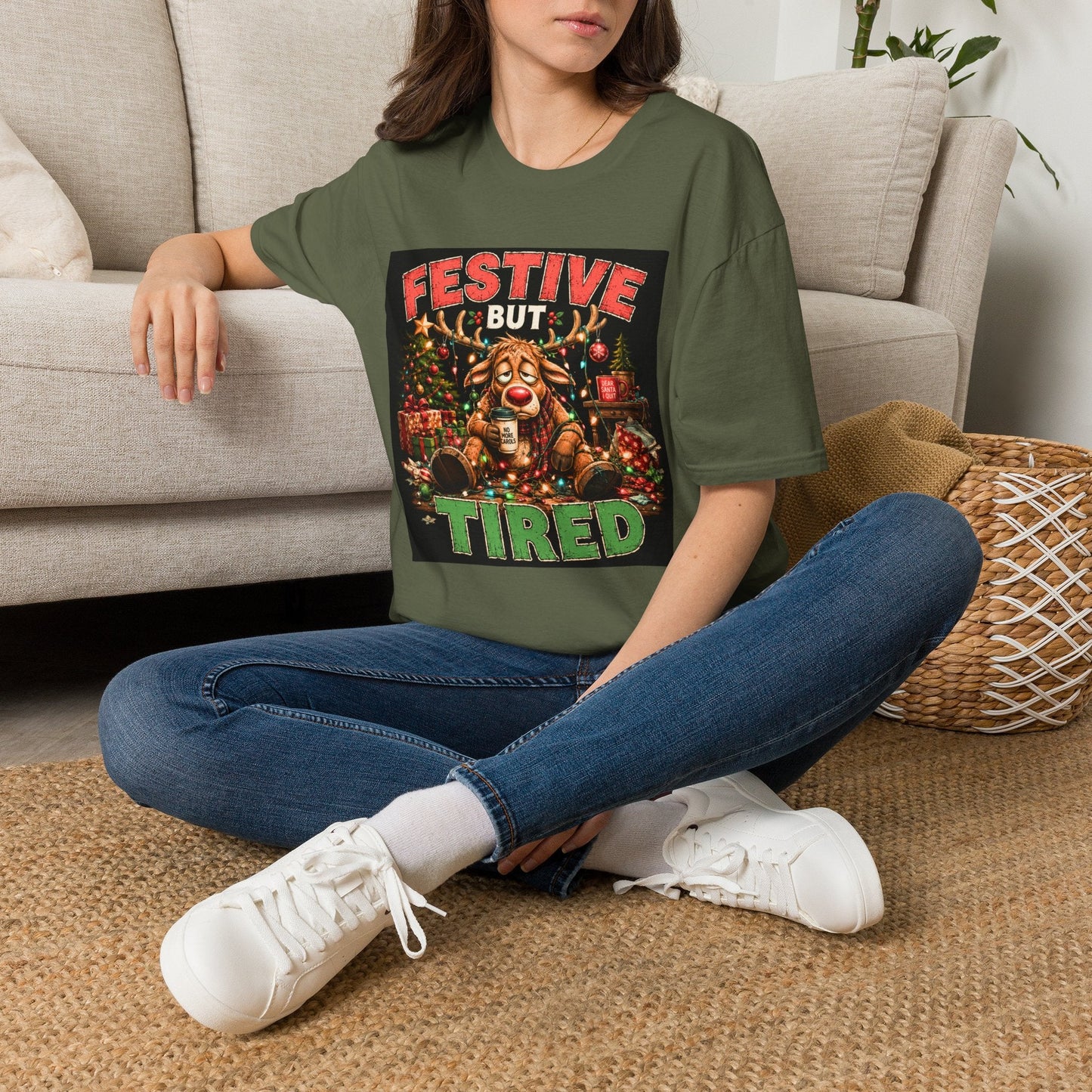 Model wearing the Festive But Tired Reindeer Christmas T-Shirt in military green with funny tired reindeer artwork.