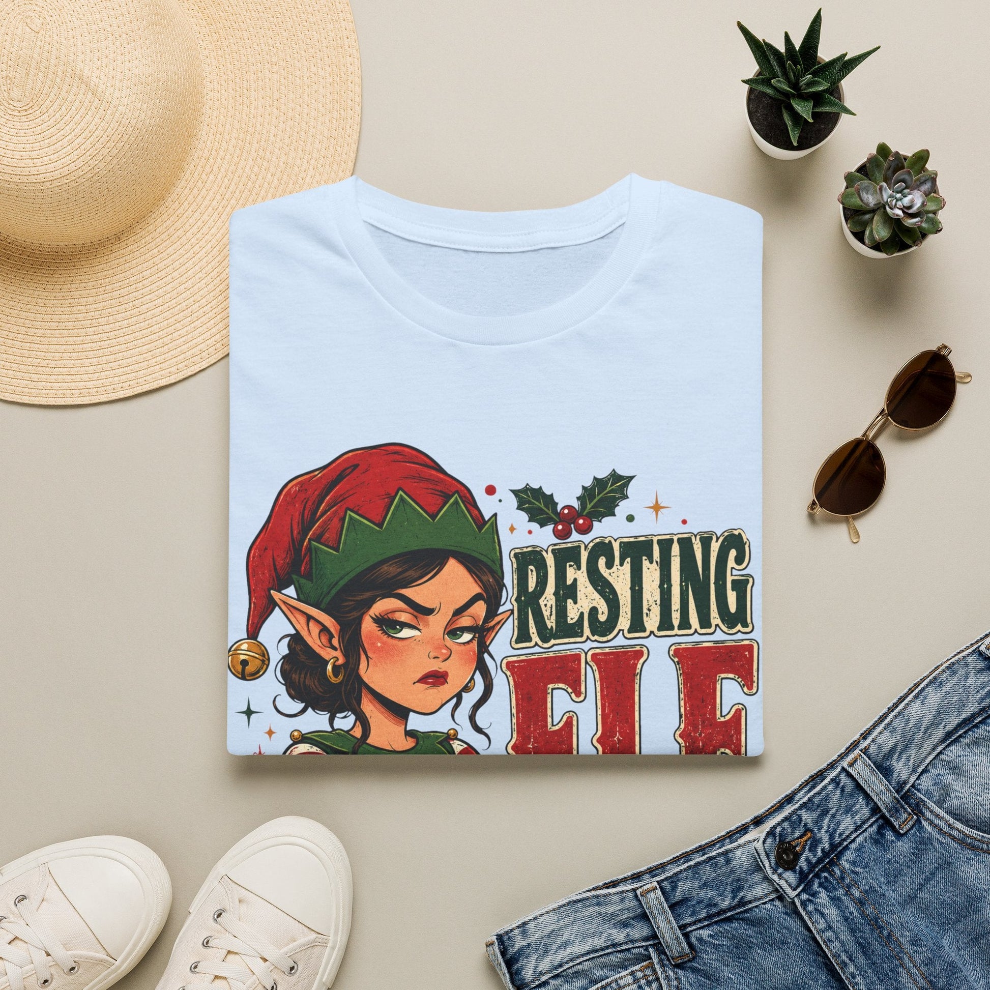 Folded Resting Elf Face Sassy Elf Christmas T-Shirt in light blue showing bold festive elf design.