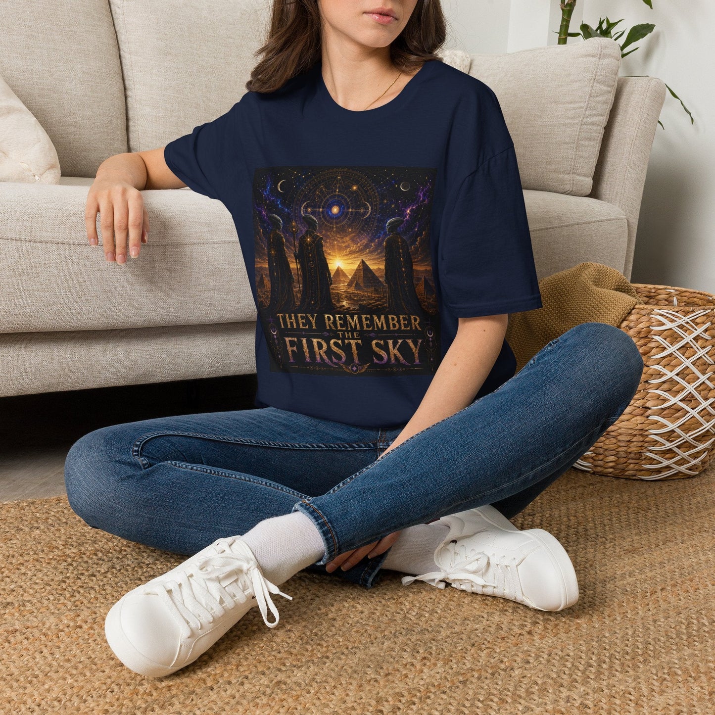 Model wearing the They Remember the First Sky T-Shirt in navy featuring robed alien watchers, pyramids, and a glowing celestial sky map design.
