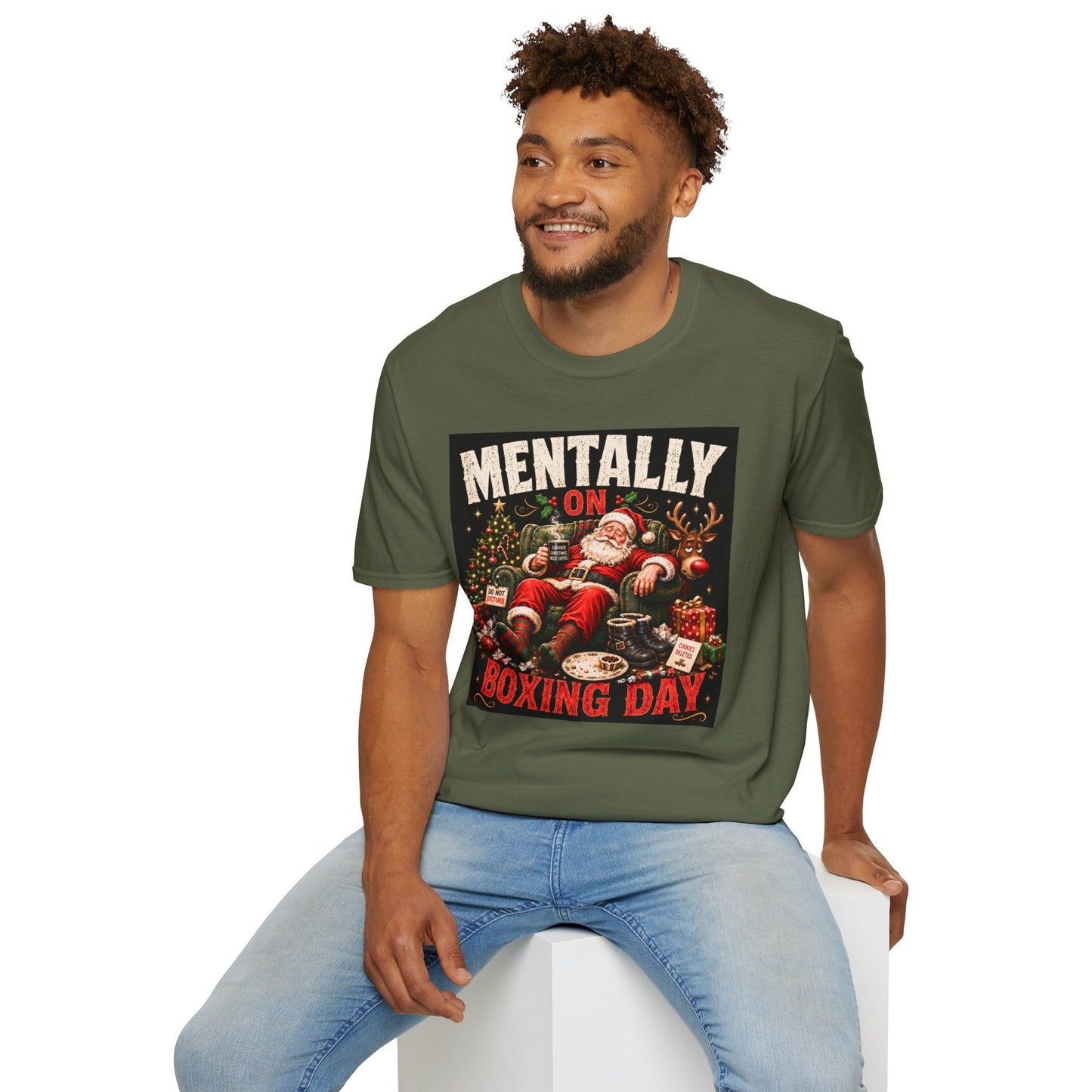 Model wearing the Mentally on Boxing Day Santa Christmas T-Shirt in military green, with funny exhausted Santa artwork.