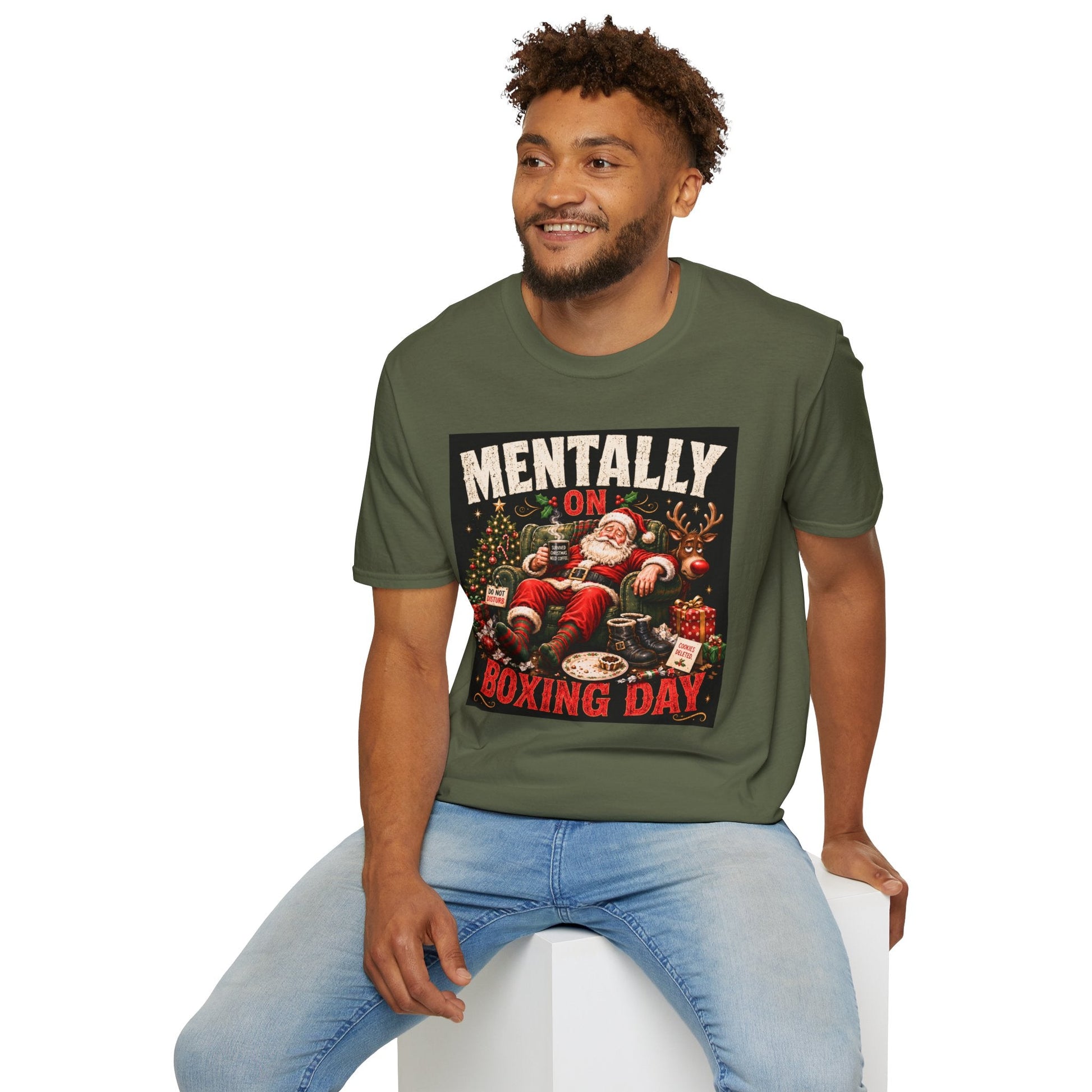 Model wearing the Mentally on Boxing Day Santa Christmas T-Shirt in military green, with funny exhausted Santa artwork.