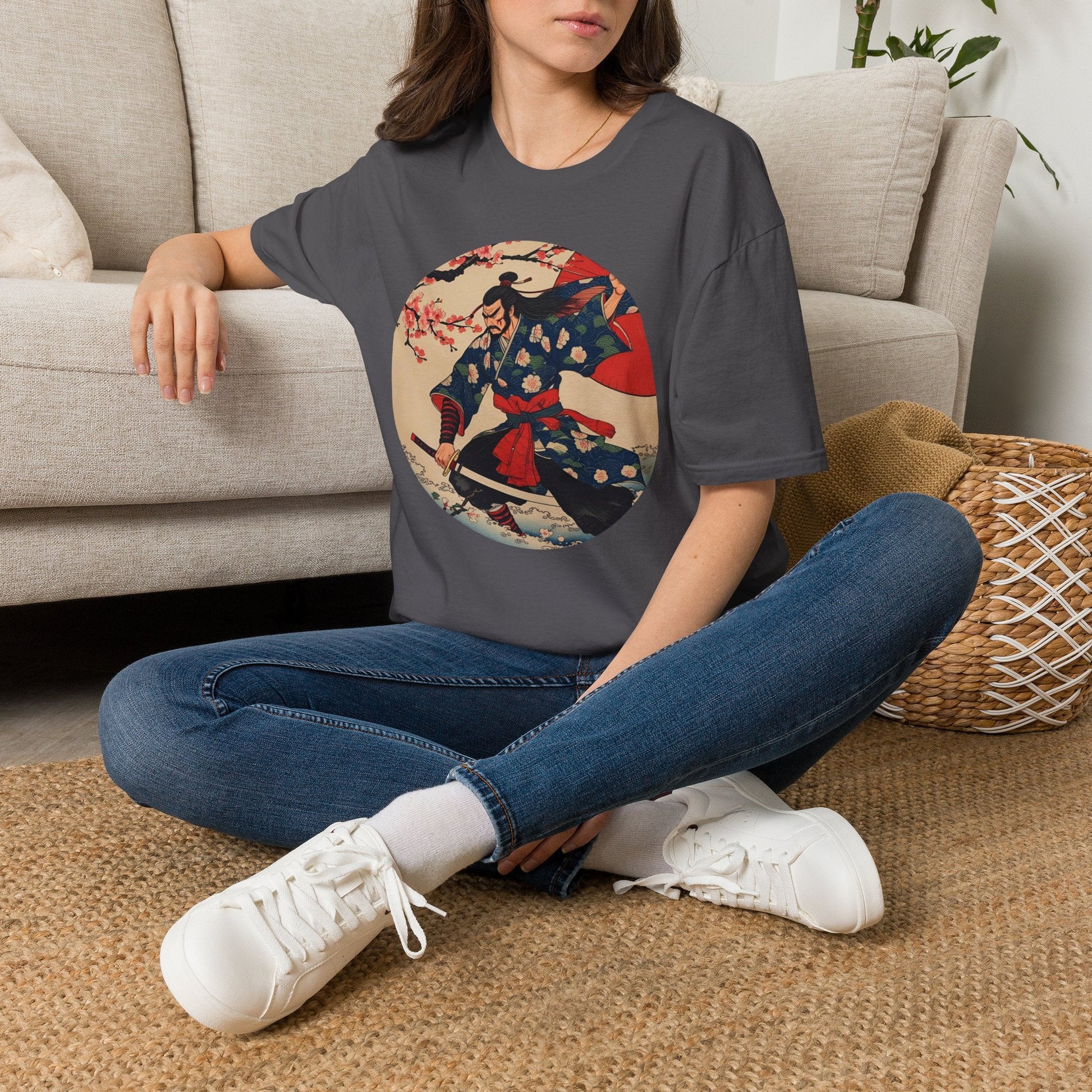Model wearing the Crimson Bloom Ronin Samurai Warrior T-Shirt in charcoal featuring a Japanese-inspired samurai in motion with cherry blossoms and crimson accents.
