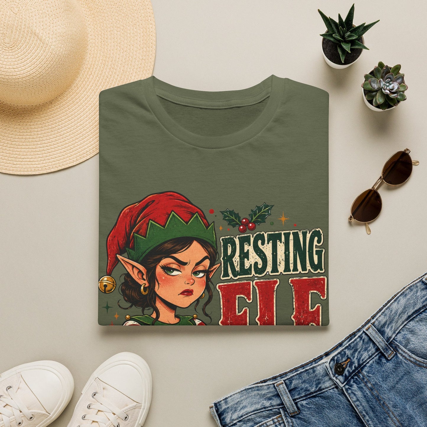 Folded Resting Elf Face Sassy Elf Christmas T-Shirt in military green showing bold festive elf design.