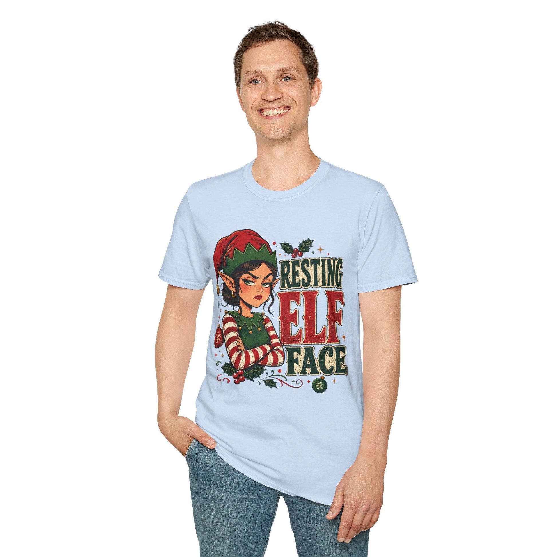 Model wearing the Resting Elf Face Sassy Elf Christmas T-Shirt in light blue with funny Christmas elf artwork.