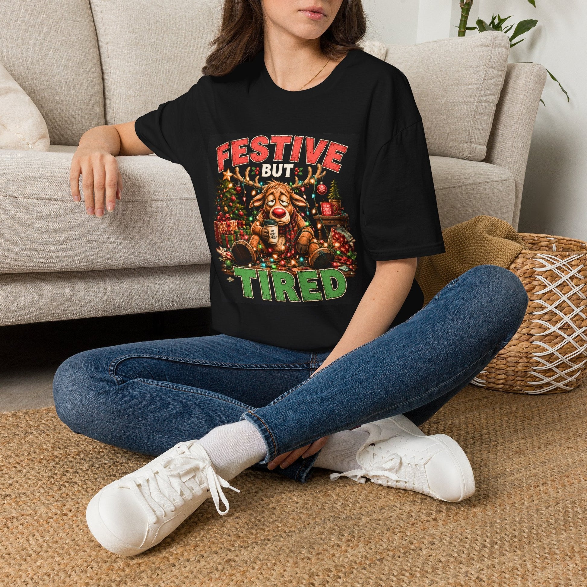 Model wearing the Festive But Tired Reindeer Christmas T-Shirt in black with funny tired reindeer artwork.