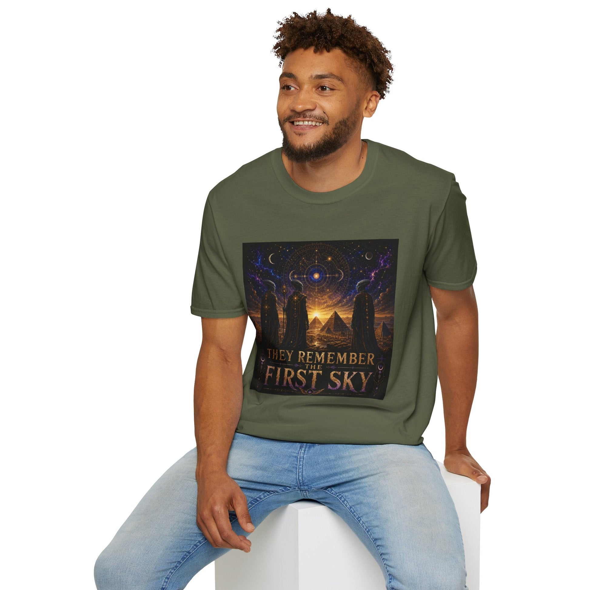 Model wearing the They Remember the First Sky T-Shirt in military green featuring robed alien watchers, pyramids, and a glowing celestial sky map design.