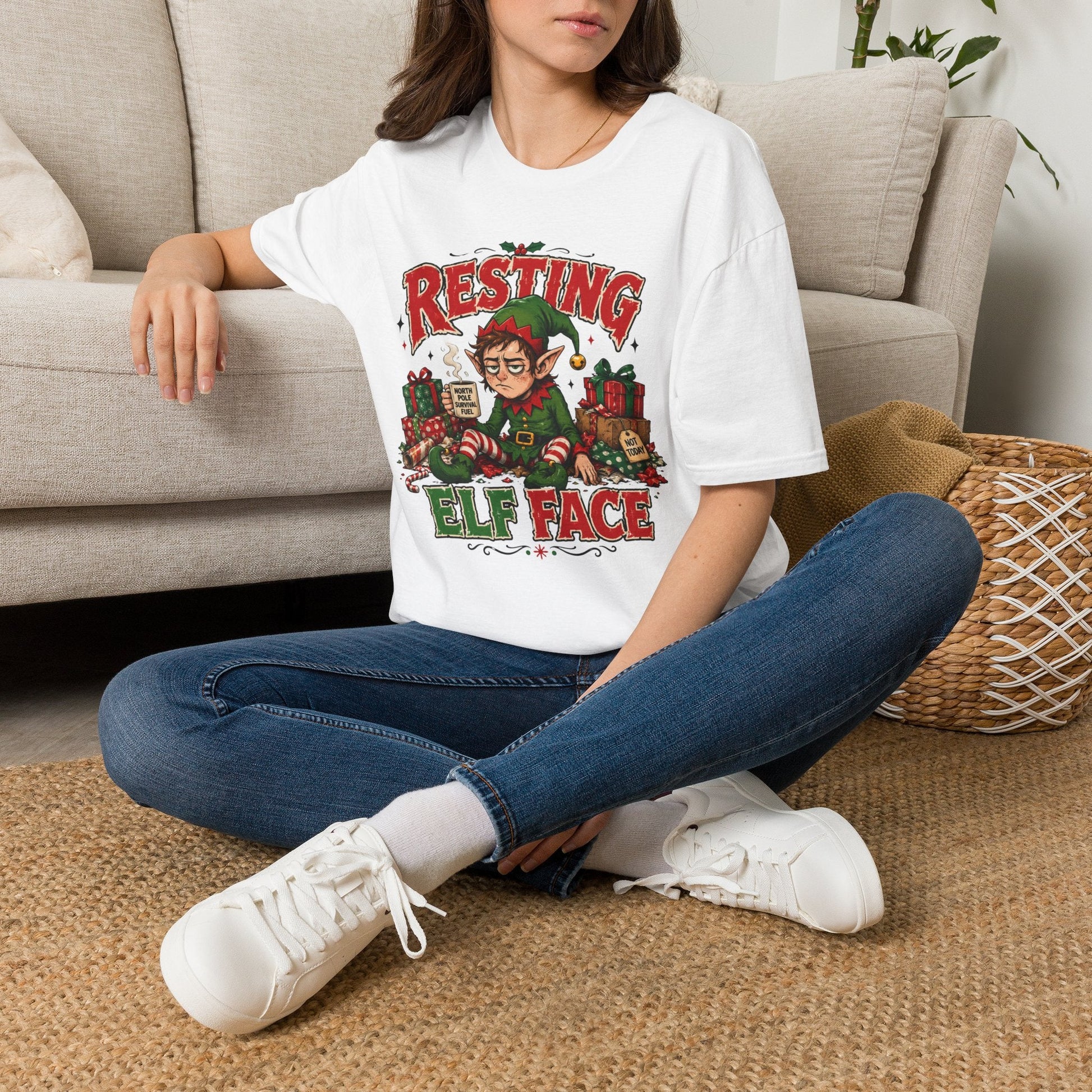 Model wearing the Resting Elf Face Christmas T-Shirt in white with funny tired elf artwork.